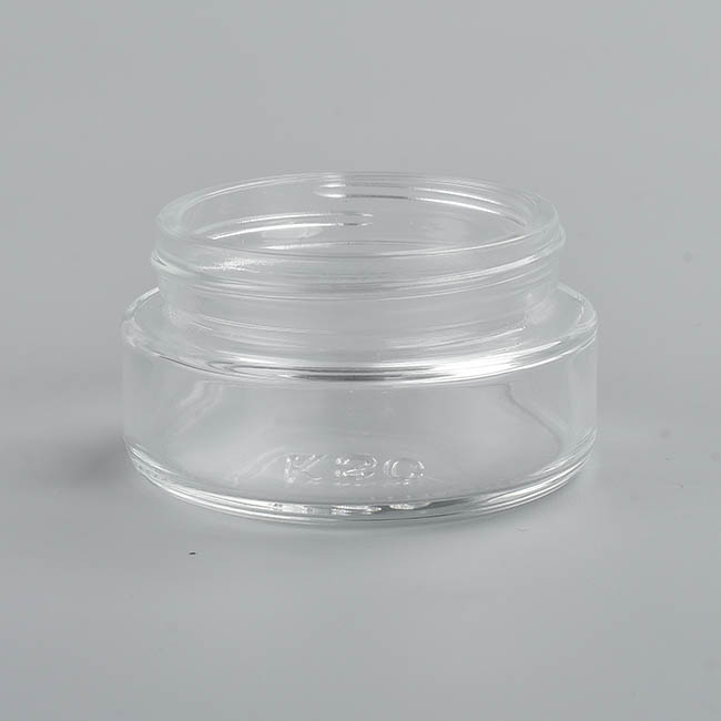 1 ounce V2 flush mount, child-resistant packaging, transparent glass base, cylindrical design.